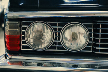 headlights of a car in black in the showroom.
