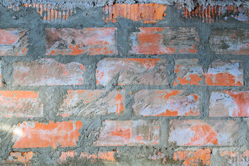 Red brick wall old dirty with peeling plaster. Brickwork. Background. Texture.