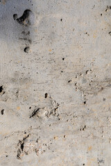 Background image of a rough concrete pour. Modern finishing of concrete walls. Holes, dents, scratches.