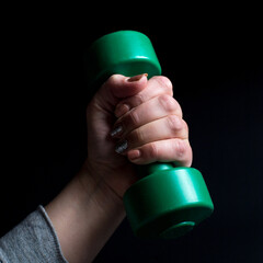 Females hand lifting little dumbbell. Female power. Fitness with dumbbells.