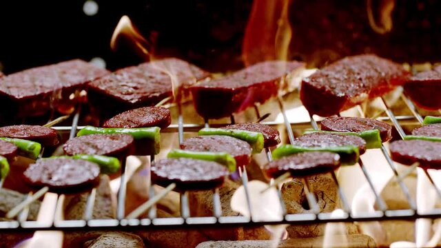 Slow motion.Turkish street vendor is cooking barbecue sausage.Turkish Sucuk. Barbecue beef sausages (Turkish sucuk) are cooking.