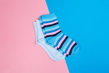 multicolored jersey socks on a pastel pink and blue background. view from above