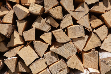 Background from stack of firewood from birch tree, for heating house, stacked in backyard, uncut wood, birch. Concept eco-friendly home heating during cold season. Overall plan. Horizontal format