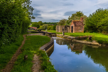 Fototapeta na wymiar A view of a flight of lock gates on the Oxford Canal beside the village of Napton, Warwickshire in summertime