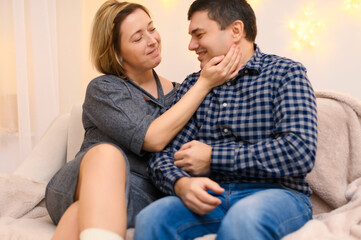 Obraz premium portrait of adult couple sitting on a sofa at home