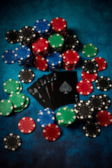Casino. Poker. Game chips lie on the table against a blue background. Game chips for betting in gambling. Poker chips. Playing cards.