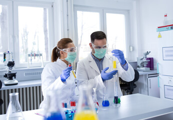 Biologists working in laboratory with chemicals