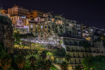Scenic night view with illuminated buildings built on the cliffs in Tropea, Calabria, Italy,