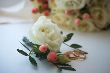 gold rings and a beautiful bridal bouquet of roses on the background. details, wedding traditions. close-up, macro