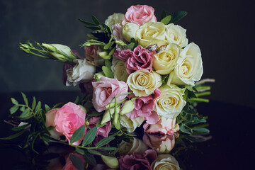 gold rings and a beautiful bridal bouquet of roses on the background. details, wedding traditions. close-up, macro