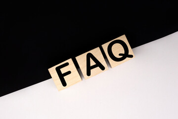 Wooden blocks with word FAQ on black baclground. Frequently asked question concept