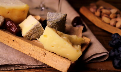 different types of cheeses with wine in glasses on a wooden surface selective focus. cheese platter.