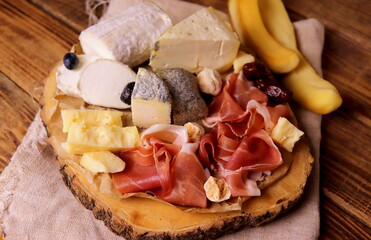 different types of cheeses with delicacy meat wooden surface selective focus. cheese platter.