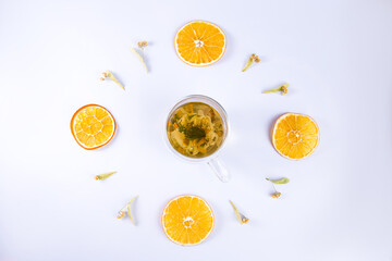 
Clock with slices of dried orange, linden flowers and a cup of herbal tea.