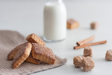 Cinnamon cookies with milk jar on white background