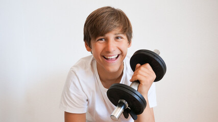 Young teenage Caucasian person happy smiling doing power lifting
