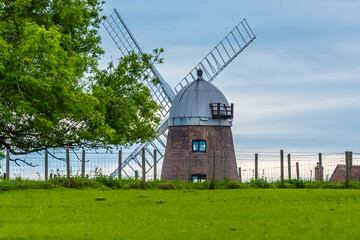 A view towards a windmill on the hilltop of the village of Napton, Warwickshire in summertime