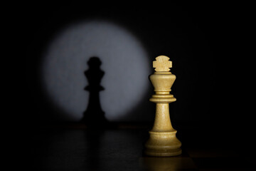 King alone on the chessboard. Concept picture of chess piece taken in studio with pinspot light effect.