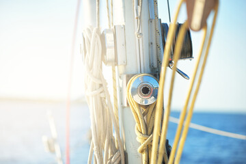 White sloop rigged yacht sailing on a clear day. A view from the deck to the mast and bow. Rigging equipment, ropes close-up. Transportation, travel, cruise, recreation, leisure activity, regatta