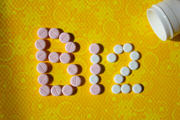 PASTILLAS DE VITAMINAS B12 SOBRE FONDO AMARILLO