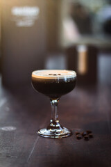 Espresso Martini cocktail drink beverage with coffee beans on a wooden table