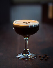 Espresso Martini cocktail drink beverage with coffee beans on a wooden table