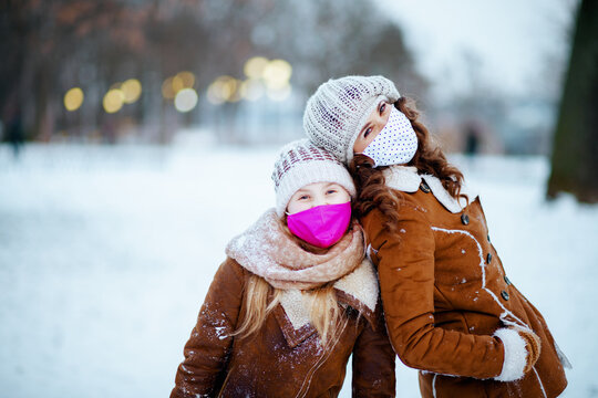 Smiling Stylish Mom And Child Outside In City Park In Winter