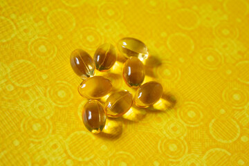 Acidos grasos Omega-3 6 Y 9 PERLAS DORADAS SOBRE FONDO AMARILLO