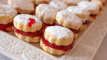  Close up of small vanilla cookies (vanilice), traditional Serbian jam sandwich cookies  covered by powdered sugar