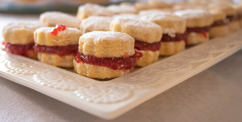 Close up of small vanilla cookies (vanilice), traditional Serbian jam sandwich cookies  covered by powdered sugar