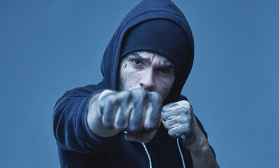 Portrait of robber giving a punch and ready to robbery the money. Aggression, gangsterism concept....