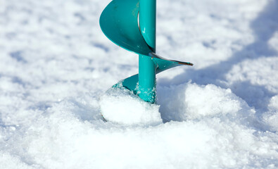 Ice augers for fishing. Winter frosty fishing on the river. Winter fishing