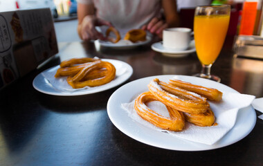 Churros in a plate. Beautiful close up of spanish round shaped churros served in a restaurant for breakfast.