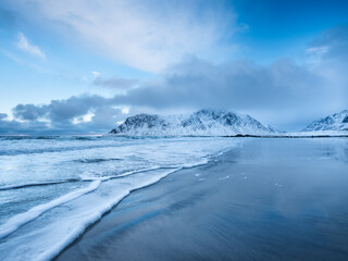 Mountains, beach and wave. Skagsanden beach, Lofoten islands, Norway. Winter landscape near the ocean. Norway travel image
