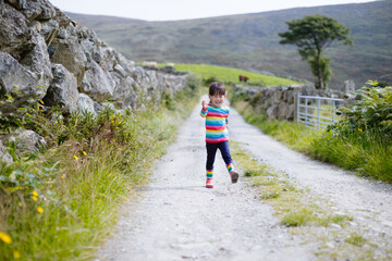 young  girl walking  on  summer countryside road