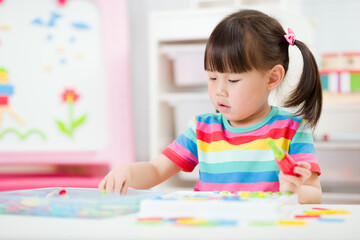 young girl playing creative toy blocks for homeschooling