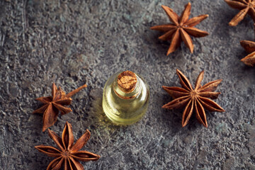 Essential oil bottle with star anise on a table