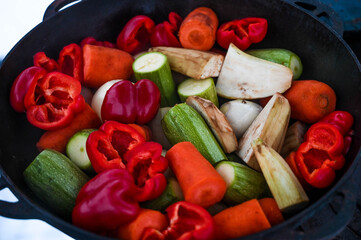 Close-up of freshly cut vegetables in a cauldron. Carrot, pepper, zucchini, onion and eggplant. Caucasian cuisine.