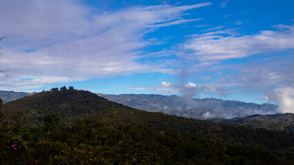Fototapeta na wymiar Paisaje con nubes sobre las montañas, paisaje con neblina
