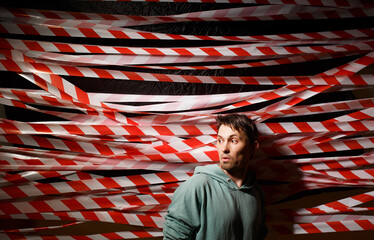 Fence tape and man. Red and white tape for the fence.