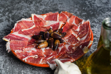 Close up of jabugo serrano ham slices with acorns, tomatoes, garlic and olive oil, Dry Spanish ham....
