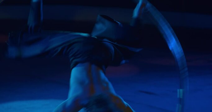 Close up of a young circus performer spinning in a massive wheel, gymnast, 4k