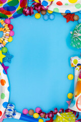 Blue background for parties and children's birthdays with party utensils such as sweets, smarties and copy space