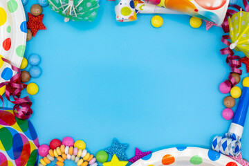 Frame of items for children's birthday or party with smarties and air snakes for invitations with copy space