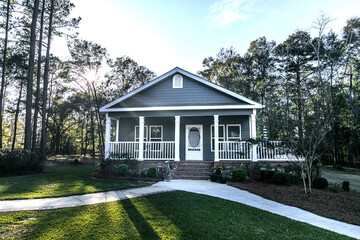 Small blue gray mobile home with a front and side porch with white railing