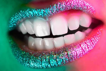Wut-Mund-Geste des Models mit Glitzern auf den Lippen. Finsteres und unheimliches Lächeln. Offene Kiefer, erschreckende oder schreiende Frau. Makroansicht des glamourösen Make-ups. © kohanova1991