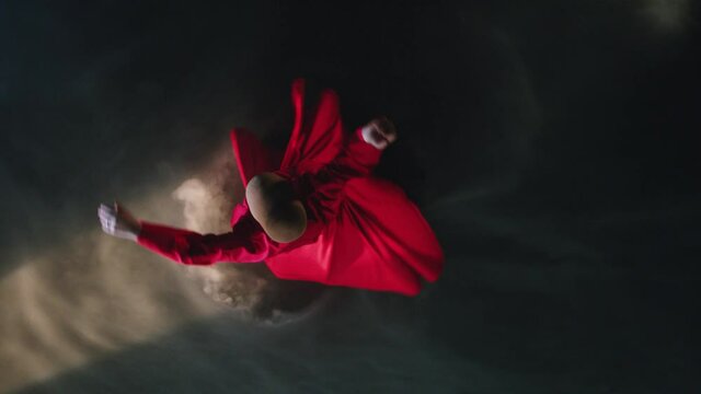 Whirling dervish with red clothes in a black background. Mevlevi Dervish slow motion.