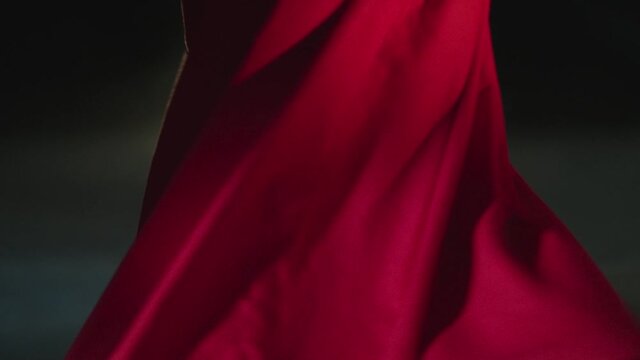 Whirling dervish with red clothes in a black background. Slow motion video.