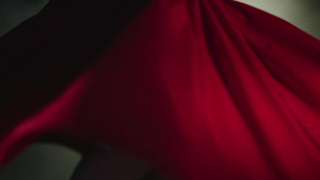 Whirling dervish with red clothes in a black background. Slow motion video.