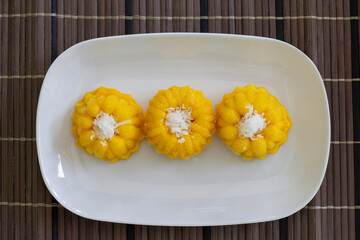 Top view of Toddy palm cake is Thai dessert in white plate on wooden table.